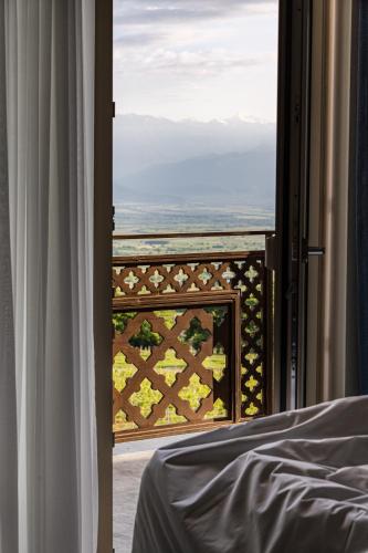 a bedroom with a view of the ocean from a window at AGARANI Estate in Tʼelavi