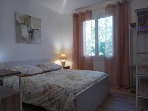 une chambre avec un lit et une fenêtre dans l'établissement Villa au pieds des Gorges de l'Ardèche, à Laval-Saint-Roman