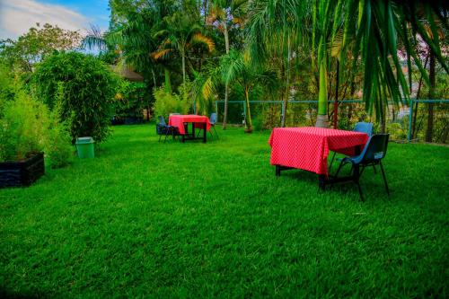 two tables and chairs in a yard with green grass at QUALITY INN HOTEL Kigali in Kigali