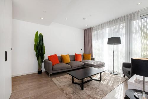 a living room with a couch with colorful pillows at Modern 2 Bed Battersea Power Station in London