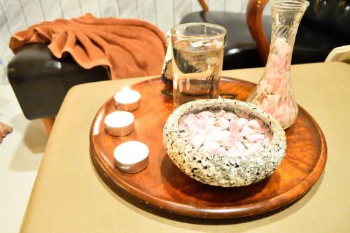 a wooden tray with a bowl and vase and candles at Neenlawat Riverside in Surat Thani