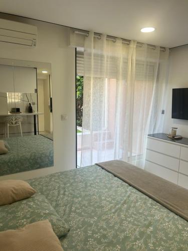 カップ・ダグドにあるgarden's suite cap d'agdeの大きなベッドと大きな鏡のある寝室