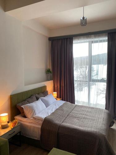 a bedroom with a bed and a large window at Tsaxkadzor, Kechi House ap 26 in Tsaghkadzor