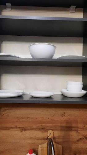 a shelf with white bowls and plates on it at Tsaxkadzor, Kechi House ap 26 in Tsaghkadzor