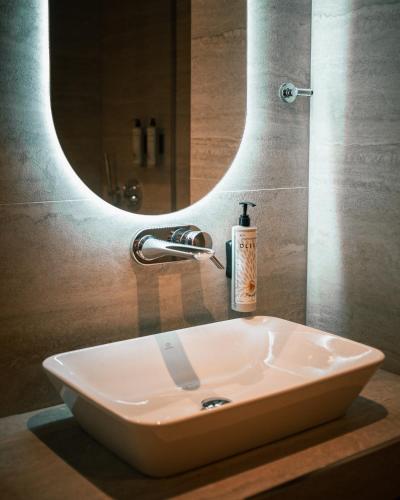 a white sink in a bathroom with a mirror at Elar Hotel in Sarandë