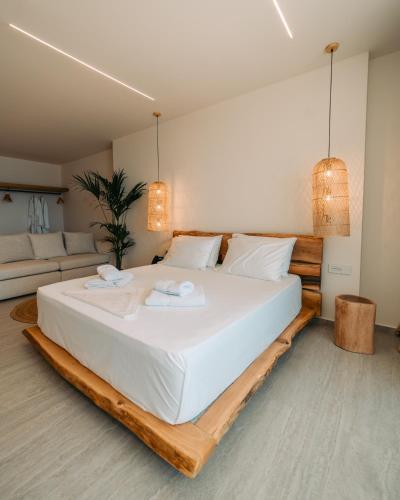 a bedroom with a large white bed with two towels at Elar Hotel in Sarandë