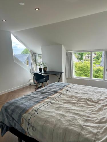 a bedroom with a large bed and a desk at Ruime slaap kamer met werkplek en privé badkamer Leeuwarden bij Jacqueline in Leeuwarden