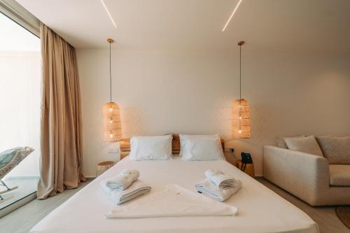 a bedroom with a white bed with towels on it at Elar Hotel in Sarandë