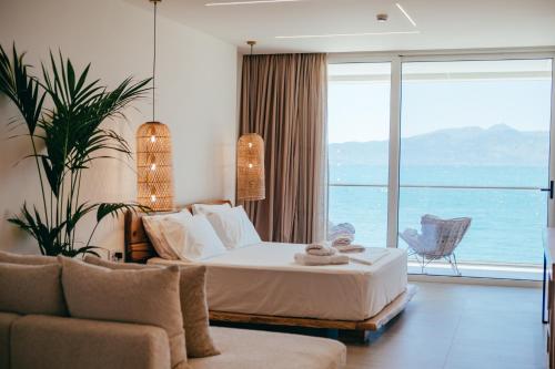 a bedroom with a bed and a large window at Elar Hotel in Sarandë