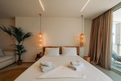 a bedroom with a white bed with towels on it at Elar Hotel in Sarandë