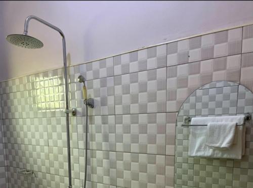 a bathroom with a shower with a glass door at Pearl Season B&B in Gulu