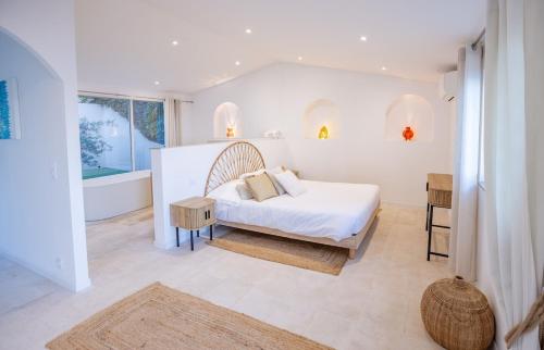- une chambre blanche avec un lit et une baignoire dans l'établissement Superb Villa, Incredible sea view Heated swim pool, à Sainte-Maxime