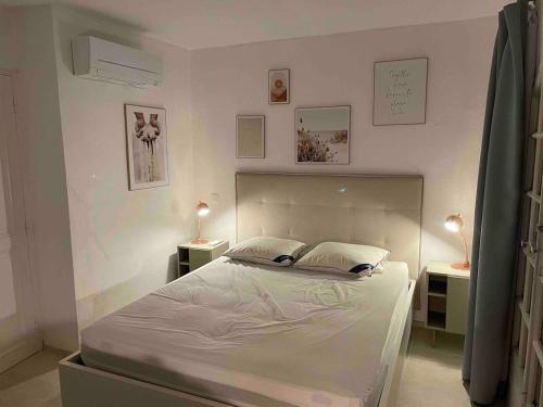 une chambre avec un grand lit avec deux tables de nuit dans l'établissement Maison du Bonheur Newly renovated house, private garden and 12x4m mooring, à Port Grimaud