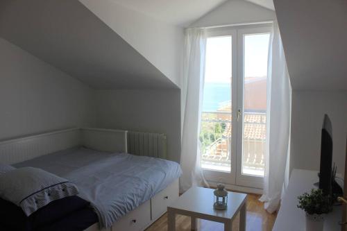 a bedroom with a bed and a large window at Rooftop sea view apartment in Split