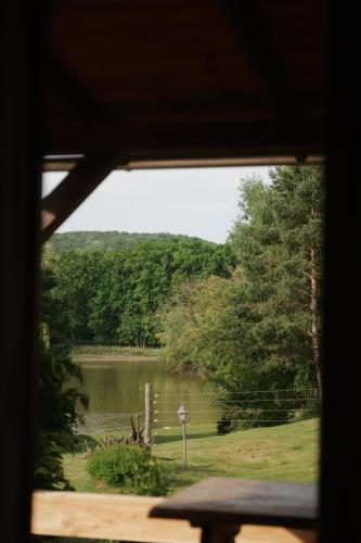 a view of a lake from a window at Wild&Free Private Lake in Nagycsepely
