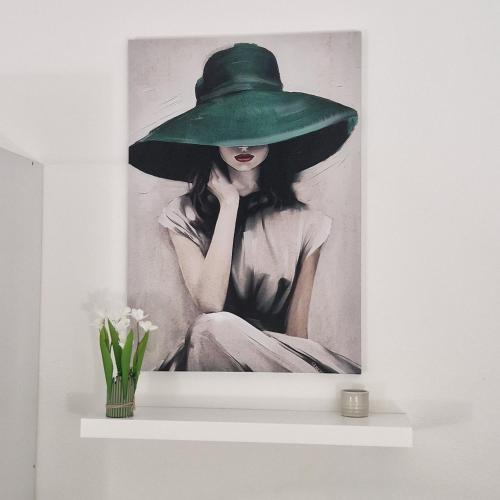 a painting of a woman wearing a green hat at SANTA VENERE Apartments "PARCHEGGIO interno MOTO-AUTO" Ricarica auto Elettriche in Tropea