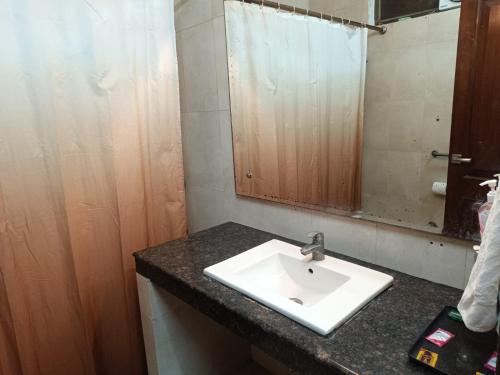a bathroom with a sink and a mirror at Pooja residency in Gurgaon