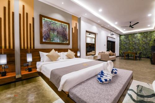 Un dormitorio con una cama grande y una sala de estar. en Madu River Reach, en Balapitiya