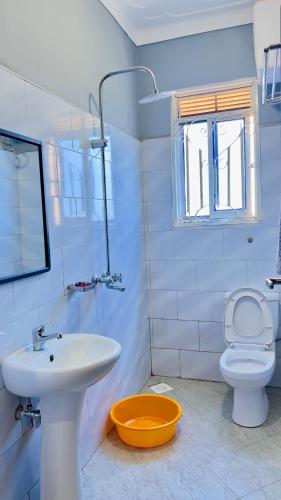 a white bathroom with a sink and a toilet at Silver Homes ug in Kampala