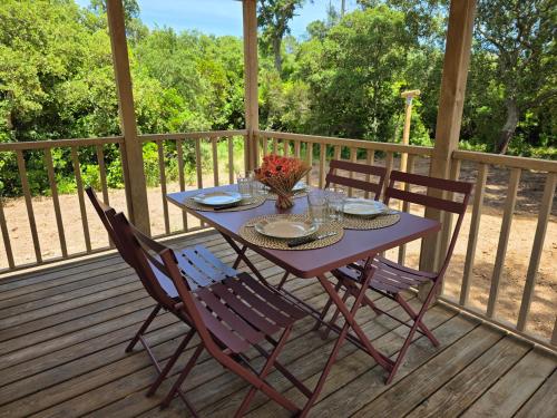 une table et des chaises violettes sur une terrasse en bois dans l'établissement La Vigne, à Lecci