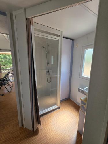 Un baño con ducha y puerta de cristal. en La Vigne, en Lecci