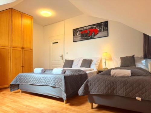 a bedroom with two beds and a red car on the wall at Entire 2nd floor of Villa with 3bedroom with large garden,BBQ,pool,sauna,free parking in Popovičky