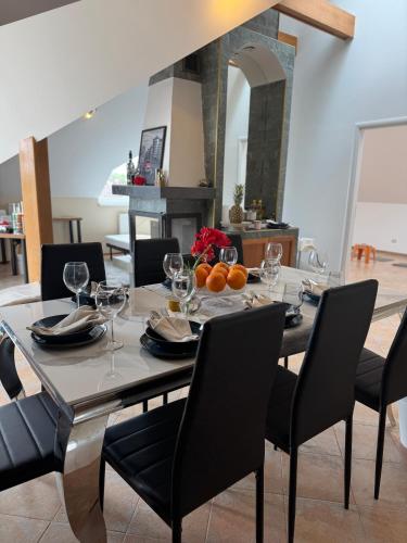 a dining room with a table with wine glasses at Entire 2nd floor of Villa with 3bedroom with large garden,BBQ,pool,sauna,free parking in Popovičky