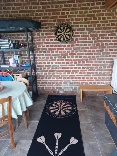 a dart board in a room with a brick wall at De Horizon in de Westhoek in Poperinge