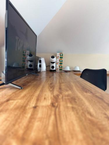 a large flat screen tv sitting on top of a wooden floor at Entire 2nd floor of Villa with 3bedroom with large garden,BBQ,pool,sauna,free parking in Popovičky