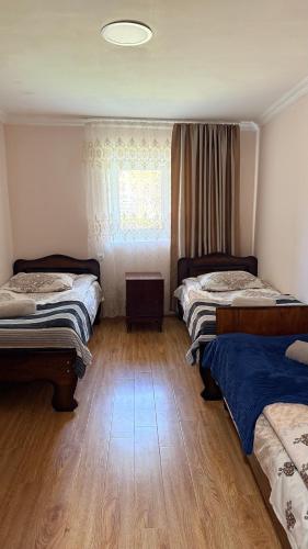 a bedroom with two beds and a window at Nizharadze's Tower in Ushguli