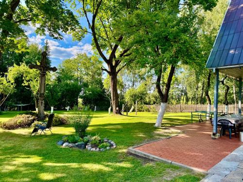 a park with a bench and trees and grass at Maple House - Sodyba Tarp Klevų in Utena