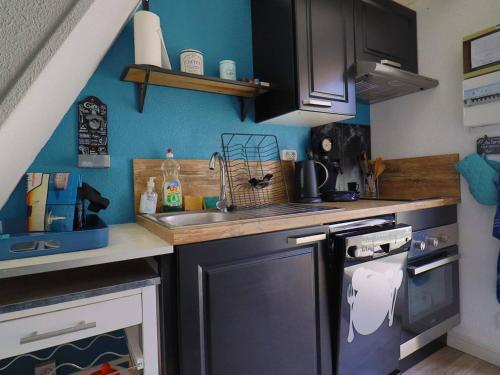 une petite cuisine avec un évier et une cuisinière dans l'établissement Maison 4 pers. avec piscine, tennis, et parking - Proche La Palmyre - FR-1-738-20, aux Mathes