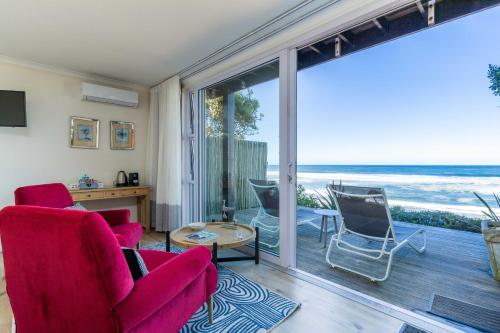 a living room with a view of the ocean at Dune Beach House in Wilderness