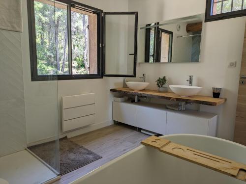 une salle de bain avec deux lavabos et une baignoire dans l'établissement Havre de paix entre mer et pinède, à Ceyreste