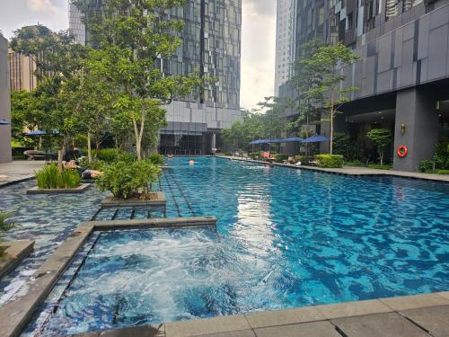 a large swimming pool in a city with tall buildings at Star Residence KLCC By Cozy in Kuala Lumpur