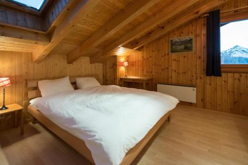 a bedroom with a large bed in a wooden room at Sunny and spacious apartment in chalet Faigaux in Veysonnaz situated in quiet area with magnificent mountain views in Veysonnaz