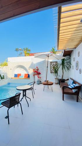 a patio with tables and chairs and a pool at Villa Padi Pakem in Pakem