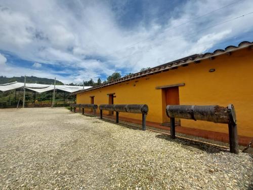 a row of benches in front of a yellow building at Hotel Campestre Ronda Ecuestre Rionegro in La Ceja