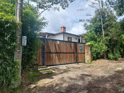 a house with a wooden gate and a fence at Hotel Campestre Ronda Ecuestre Rionegro in La Ceja