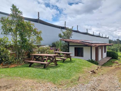 two picnic tables in front of a building at Hotel Campestre Ronda Ecuestre Rionegro in La Ceja