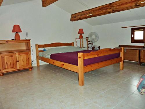- une chambre avec un lit en bois et une commode dans l'établissement Appartement 2 pièces avec piscine, proche plage, terrasse et parking à Marseillan - FR-1-387-78, à Marseillan