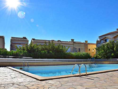 une piscine au milieu d'une cour dans l'établissement Appartement 2 pièces avec piscine, proche plage, terrasse et parking à Marseillan - FR-1-387-78, à Marseillan