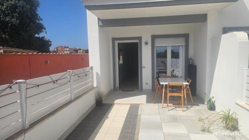 a small white house with a table and chairs on a patio at Golf residence in Ardea