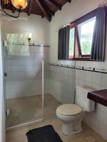 a bathroom with a toilet and a glass shower at CasaLegal in Búzios