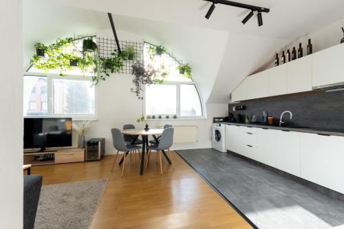 a kitchen and living room with a table and chairs at Urban Bloom apartments by Booky in Liptovský Mikuláš