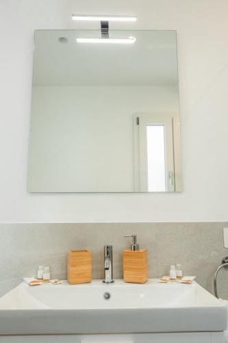 a bathroom sink with a large mirror above it at Domira - Casa Vacanze Fronte Mare in Scoglitti