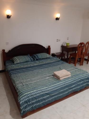 a large bed in a room with a table and chairs at Homestay 1-2pax AC room 3 including private kitchen in Siem Reap