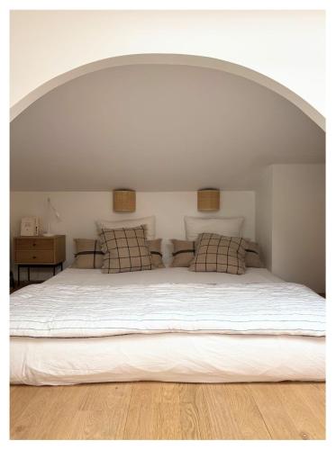 une chambre avec un grand lit blanc avec deux oreillers dans l'établissement Chouk House - Idéal Famille avec Terrasse, à Bordeaux