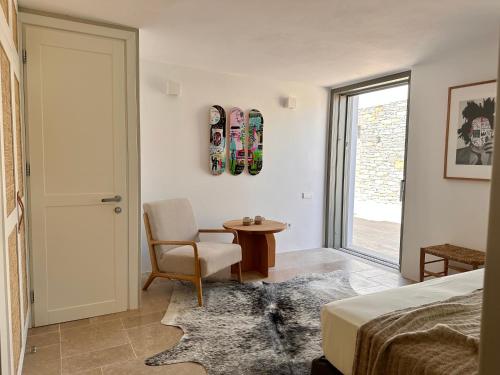 a bedroom with a bed and a chair and a table at Egeo Paros in Kampos Paros