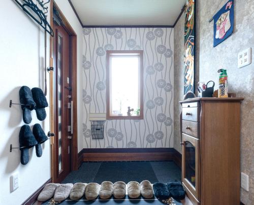 a hallway with shoes on the floor and a window at Lavie plus in Noboribetsu